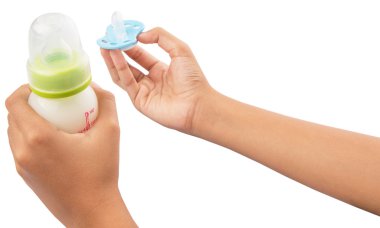 mavi bir emzik bebeğin süt şişesiyle tutan el