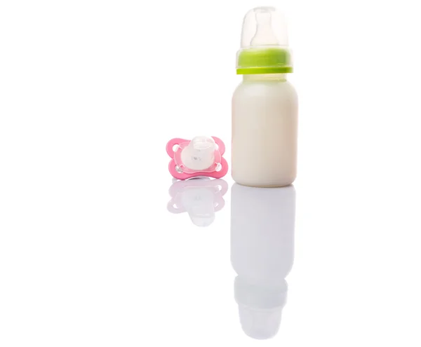 Bebé chupete y una botella de leche de fórmula de bebé — Foto de Stock