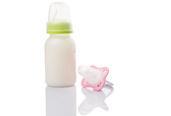 Bebé chupete y una botella de leche de fórmula de bebé — Foto de Stock
