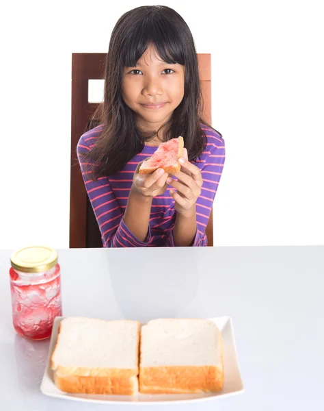 Ung flicka äter bröd — Stockfoto