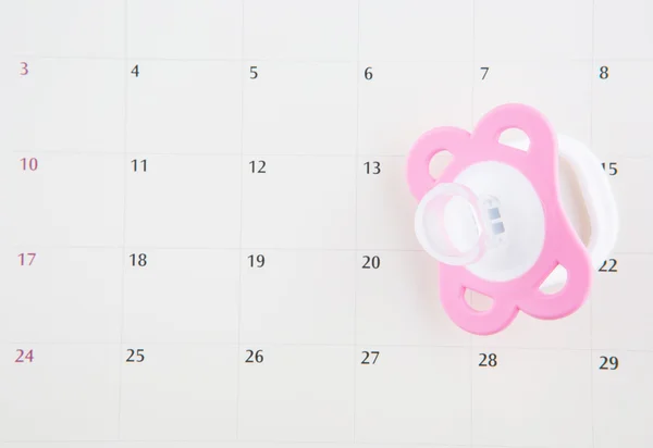 Rosa Schnuller und Kalender — Stockfoto