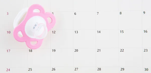 粉红色婴儿奶嘴和日历 — 图库照片