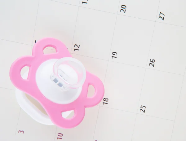 Calendario e ciuccio rosa — Zdjęcie stockowe