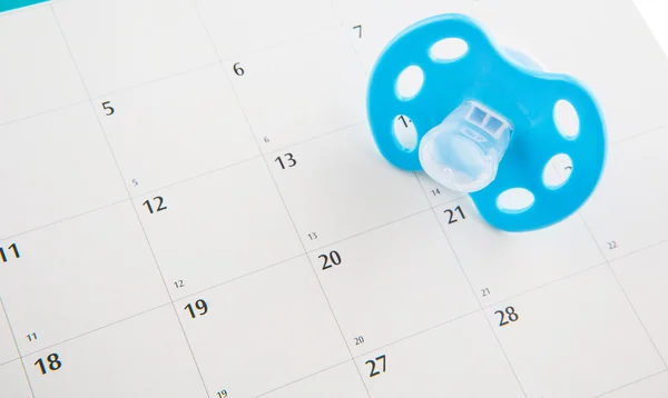 Blauer Schnuller und Kalender — Stockfoto