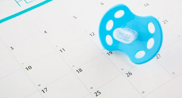 Blauer Schnuller und Kalender — Stockfoto