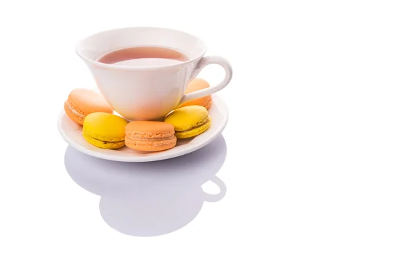 Een Kopje Thee Geel Oranje Gekleurde Macarons Witte Achtergrond — Stockfoto