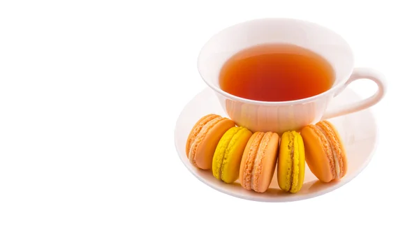 Een Kopje Thee Geel Oranje Gekleurde Macarons Witte Achtergrond — Stockfoto