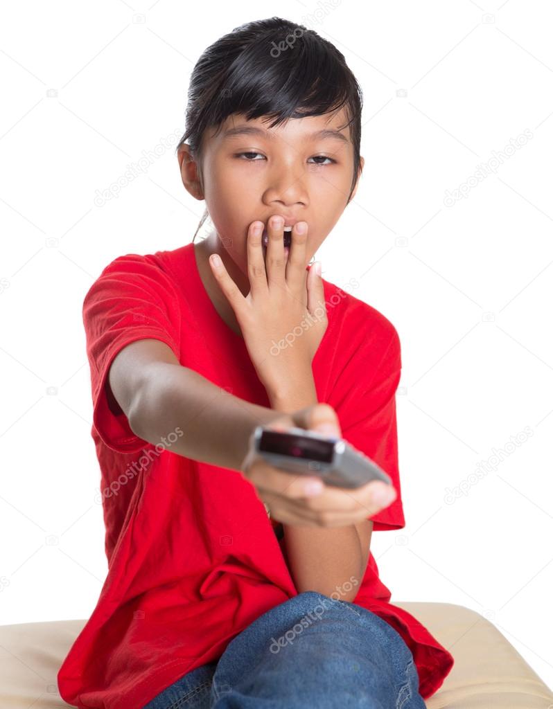 Young Asian Girl With TV Remote Device