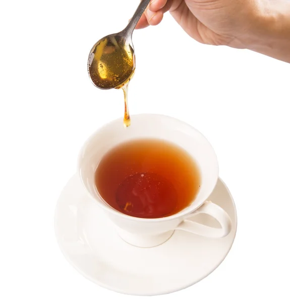 Miel de mezcla de mano femenina con té — Foto de Stock