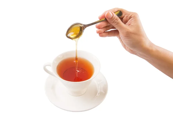Kvinnlig Hand blanda honung med te — Stockfoto