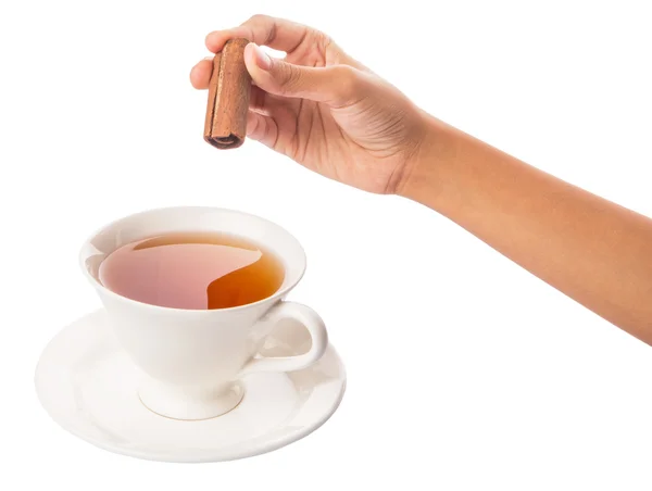 Weibliche Hand mit einer Tasse Tee und Zimtstange — Stockfoto