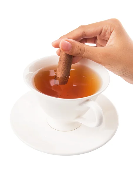 Mano femenina con una taza de té y palillo de canela — Foto de Stock