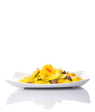 Malezya vejetaryen beyaz arka plan üzerinde Jeruk Mangga Muda Asam Boi veya kurutulmuş Demirhindi ve biber dilimleri beyaz bir plaka ile genç mango turşusu meze