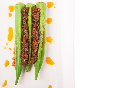 Derin kızarmış darlığı chili sambal beyaz arka plan üzerinde beyaz tabakta haşlanmış ham bamya ya da bayanlar parmak