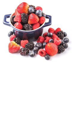 Çilek, böğürtlen, yaban mersini ve beyaz arka plan üzerinde mavi bir tek tencerede ahududu