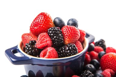 Çilek, böğürtlen, yaban mersini ve beyaz arka plan üzerinde mavi bir tek tencerede ahududu