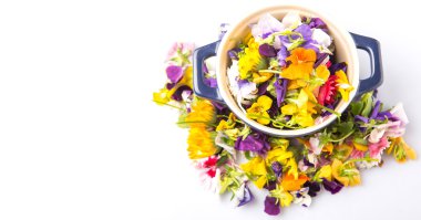 Beyaz arka plan üzerinde yenilebilir çiçek salata mavi bir tek tencerede karıştırın