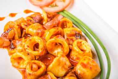 Yeşil soğan ve domates beyaz tabakta da sıcak ve baharatlı sambal ot chili soslu kızarmış kalamar Malezya tabak.