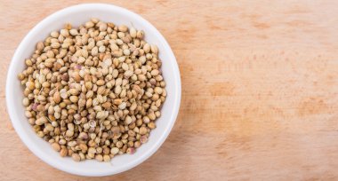 Kişniş ahşap yüzey üzerinde beyaz kase