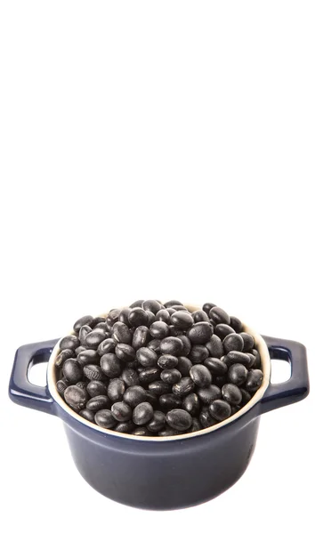 白い背景の上の青い鍋で黒豆 — ストック写真