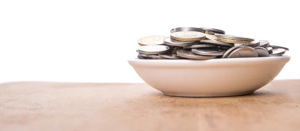 Monedas en tazón blanco — Foto de Stock