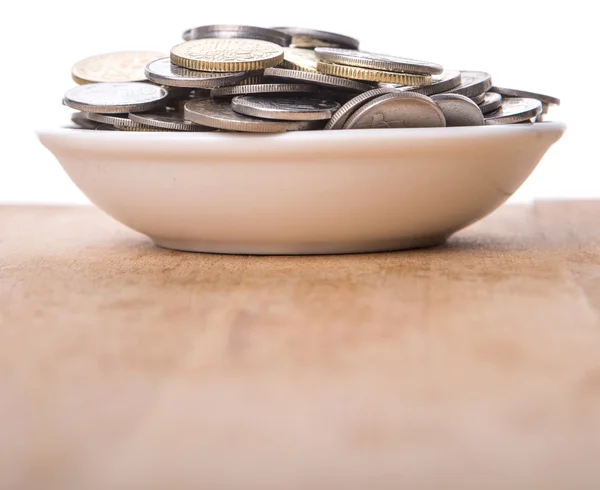 Monedas en tazón blanco — Foto de Stock