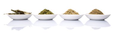 Biberiye, maydanoz, defne yaprağı ve kekik beyaz arka plan üzerinde beyaz kase otlar çeşitli