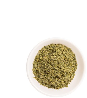 Beyaz arka plan üzerinde beyaz kase Maydanoz otlar kurutulmuş