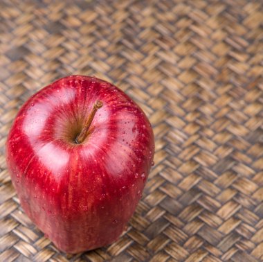 Hasır arka plan üzerinde kırmızı elmalar