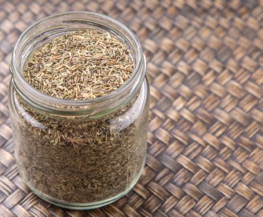 Kekik otlar bir mason kavanoza Hasır arka plan üzerinde kurutulmuş