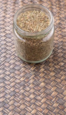 Kekik otlar bir mason kavanoza Hasır arka plan üzerinde kurutulmuş