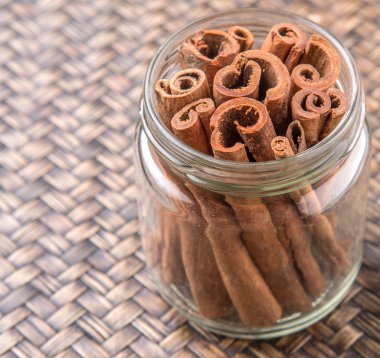 Kabuk tarçın baharat Hasır arka plan üzerinde bir mason kavanoza