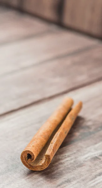 Cinnamon stick spice over weathered wooden background