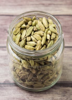 Kakule baharat yıpranmış ahşap arka plan üzerinde bir mason kavanoza