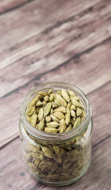 Kakule baharat yıpranmış ahşap arka plan üzerinde bir mason kavanoza