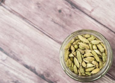 Kakule baharat yıpranmış ahşap arka plan üzerinde bir mason kavanoza