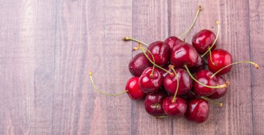 Ahşap arka plan üzerinde kırmızı kiraz meyve