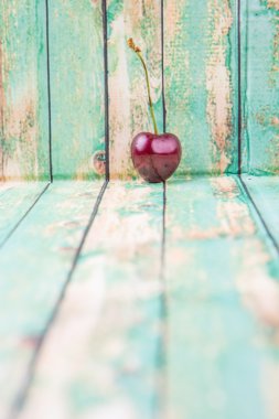 Kiraz meyve yıpranmış ışık yeşil ahşap arka plan üzerinde