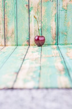 Kiraz meyve yıpranmış ışık yeşil ahşap arka plan üzerinde