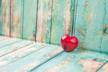 Kiraz meyve yıpranmış ışık yeşil ahşap arka plan üzerinde