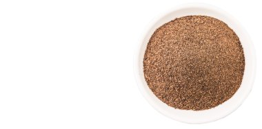 Beyaz arka plan üzerinde beyaz bir kase kuru işlenmiş çay yaprakları