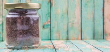 Kurutulmuş işlenmiş çay bir mason kavanoza rustik yıpranmış ahşap arka plan üzerinde bırakır.