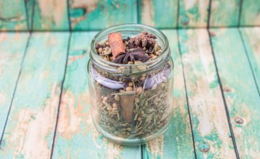 Otlar ve baharatlar mason kavanoza yıpranmış ahşap arka plan üzerinde karışımı