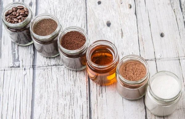 咖啡豆 咖啡粉 可可粉 蜂蜜制成的茶叶叶片在梅森罐子里超过风化的木制背景 — 图库照片