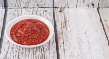 Taze rustik ahşap arka plan üzerinde beyaz kase domates pureed