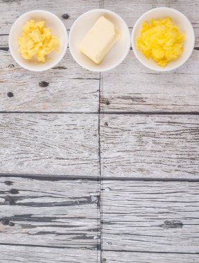 Tereyağı, margarin ve ghee rustik ahşap arka plan üzerinde beyaz kase bloğu