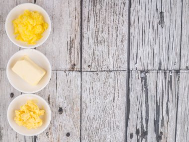 Tereyağı, margarin ve ghee rustik ahşap arka plan üzerinde beyaz kase bloğu