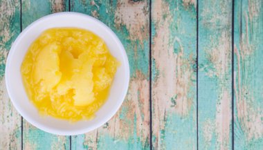 Hint ghee olarak ahşap arka plan üzerinde beyaz kase kase