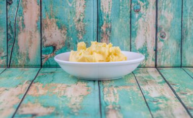 Ahşap arka plan üzerinde beyaz kase margarin kase