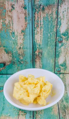 Ahşap arka plan üzerinde beyaz kase margarin kase